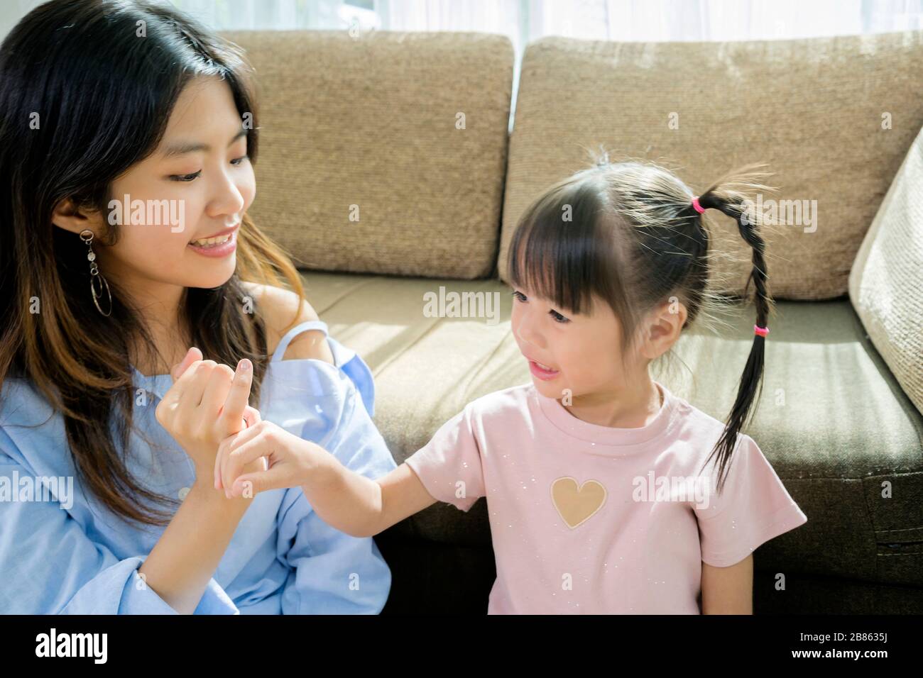 The sisters will reconcile. Using their fingers together, they are in the house and have activities to do together. Stock Photo