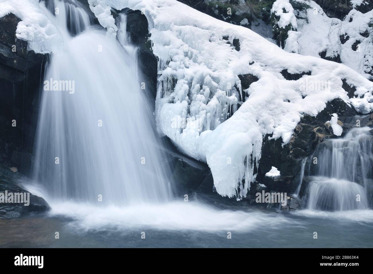 Active Waterfall A small active waterfall. Clean mountain stream, snowy winter landscape ...