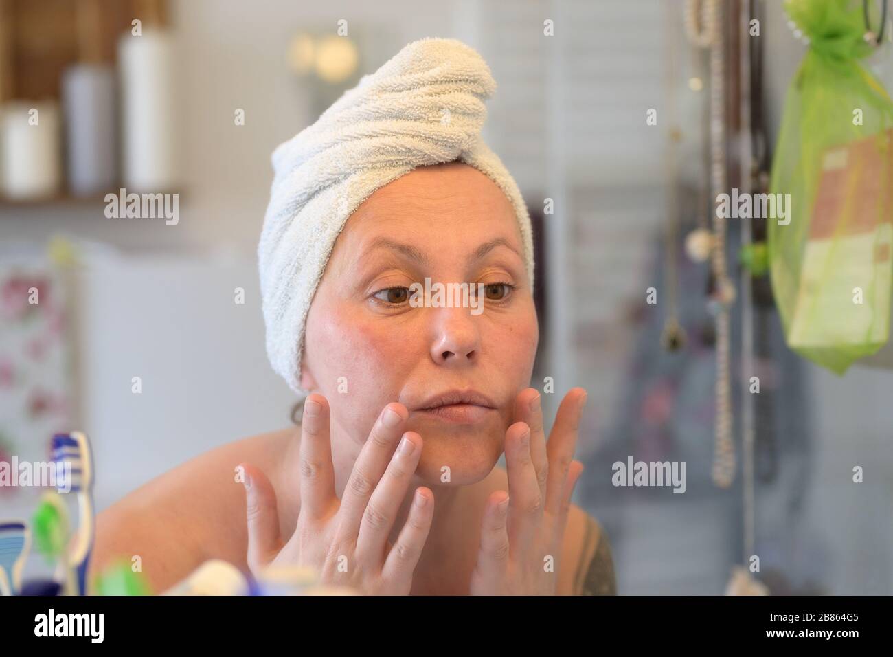 Woman wearing a towel on her wet hair after showering taking a close