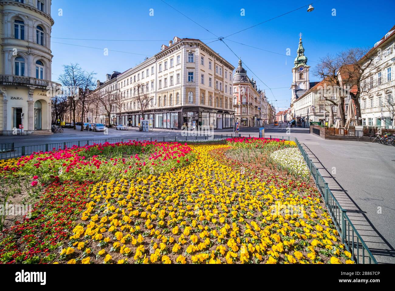 View from Eisernes Tor to street Herrengasse in deserted town Graz, Styria at virus quarantine on spring with beatifull flowers  and the old buildings Stock Photo