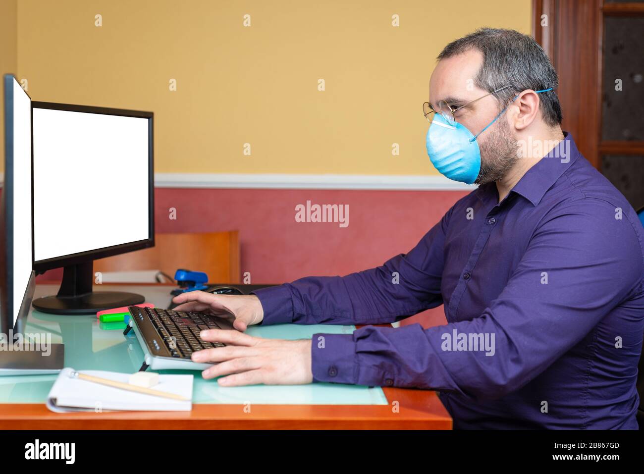 man with medical mask  working in house. Teleworking concept Stock Photo
