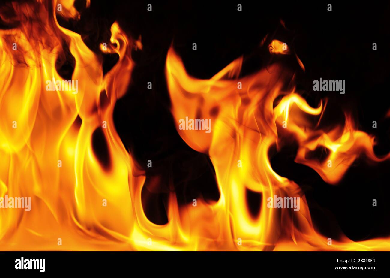 Closeup photo of bright orange yellow flame on a black background