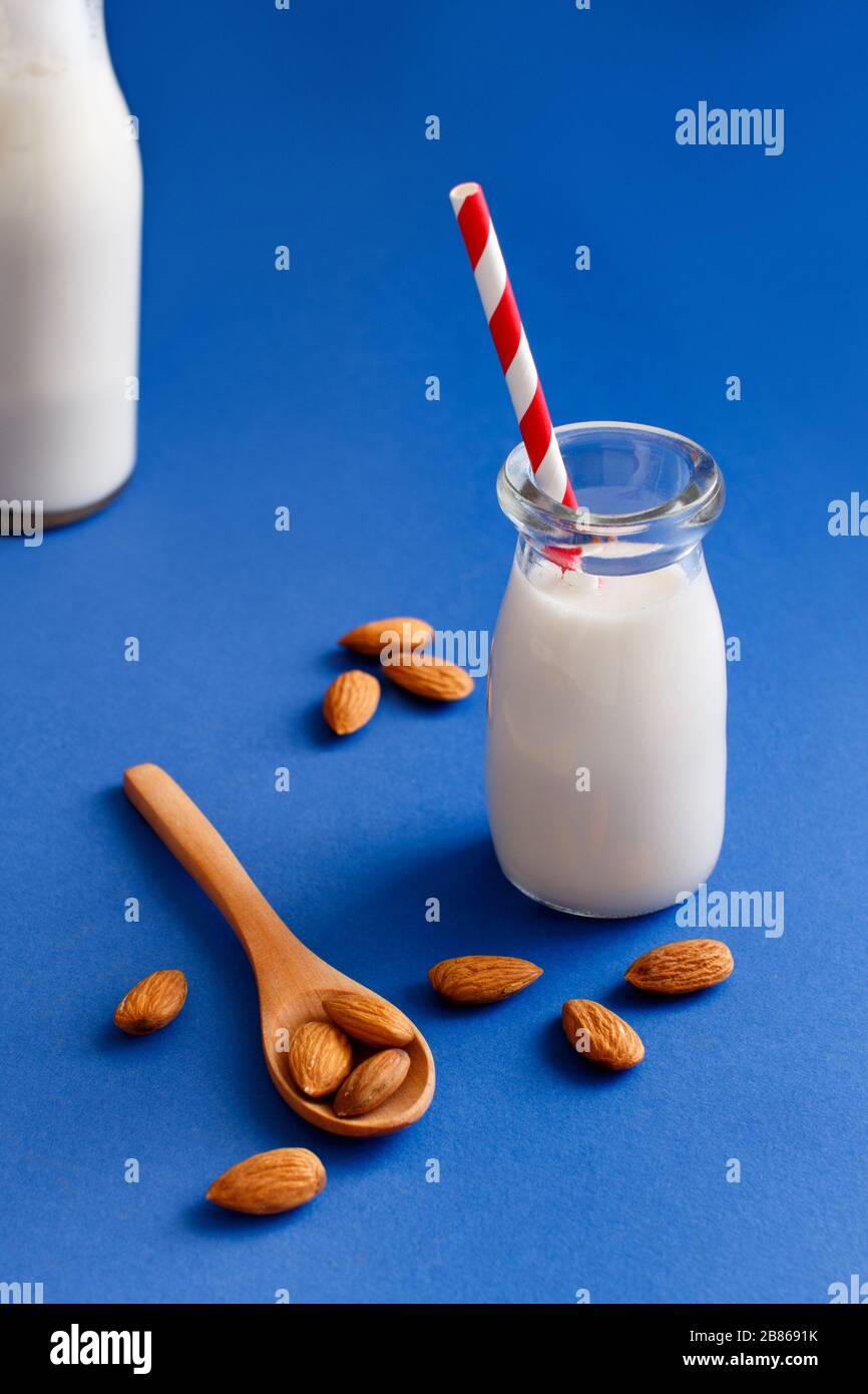 Vegan almond milk, non dairy alternative milk on a blue background
