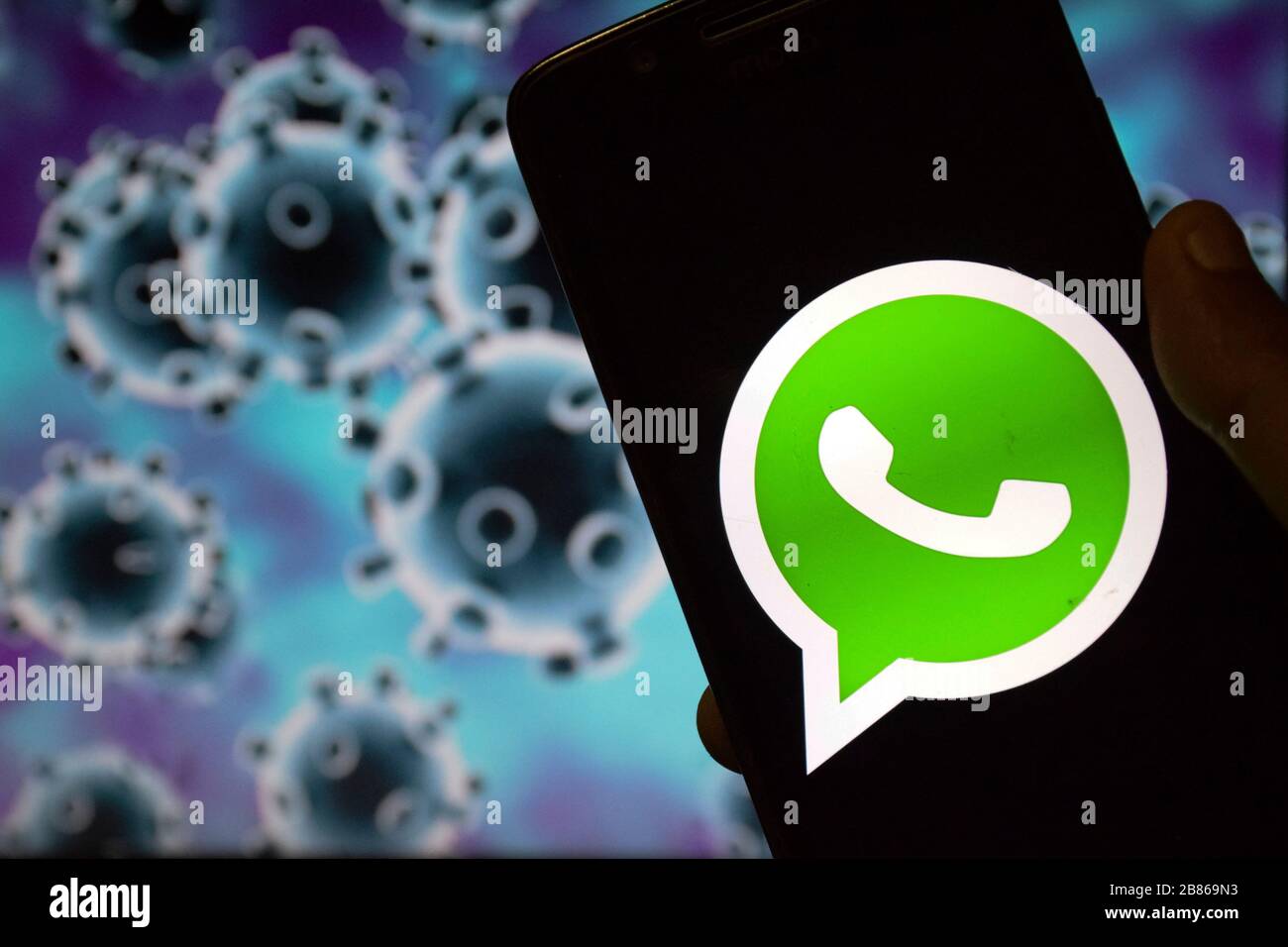 India. 20th Mar, 2020. In this photo illustration the Whatsapp logo seen displayed on a smartphone with a computer model of the COVID-19 coronavirus on the background. Credit: SOPA Images Limited/Alamy Live News Stock Photo