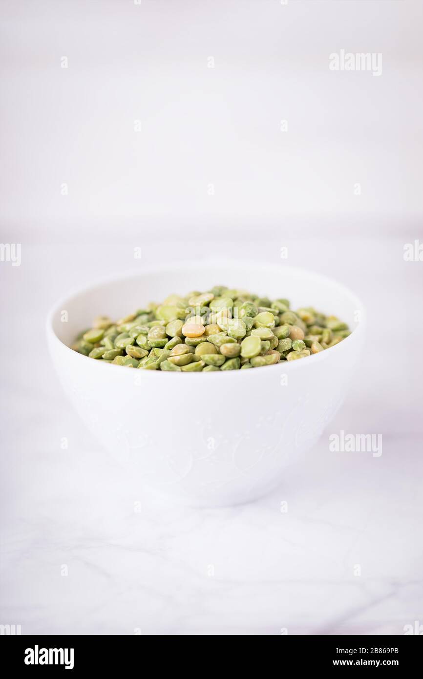 Dry split light green peas in a white cup Stock Photo