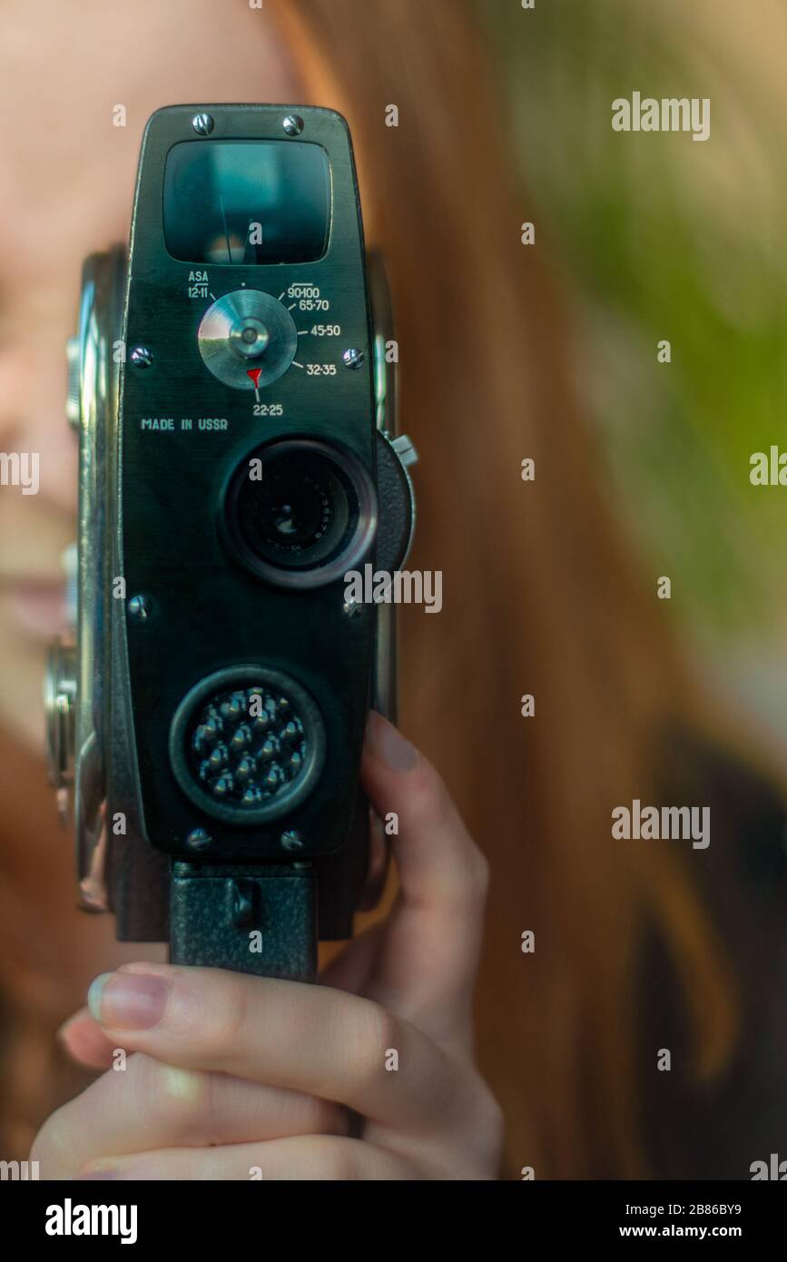 Young Woman Independent Filmmaker Films Movie With Vintage Film Camera