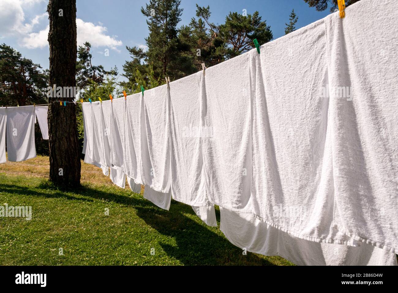fresh clean white towels drying on washing line in outdoor Stock Photo