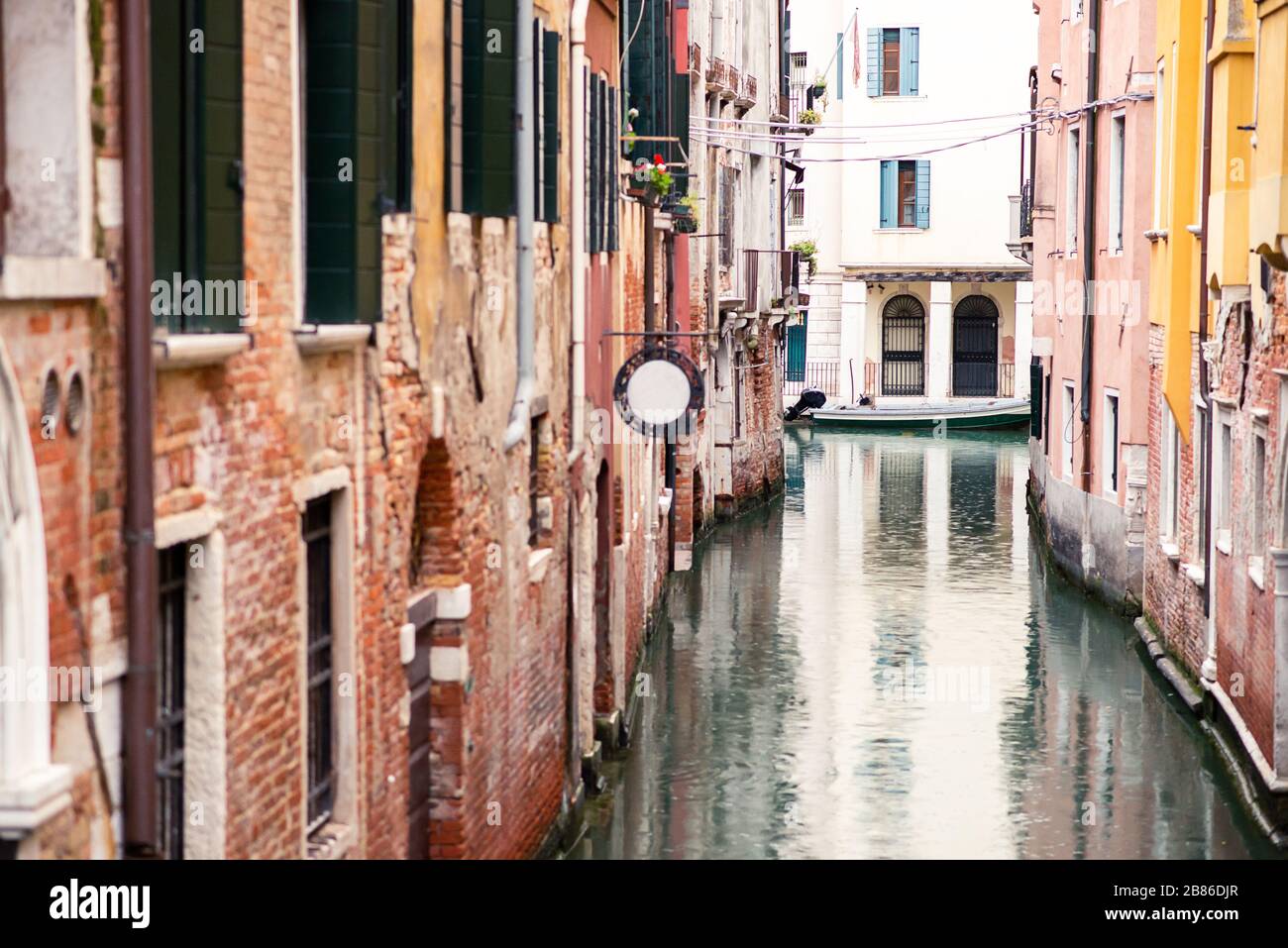 Picturesque Old Venice Canal with Red Buildings and Boat. Rainy Weather