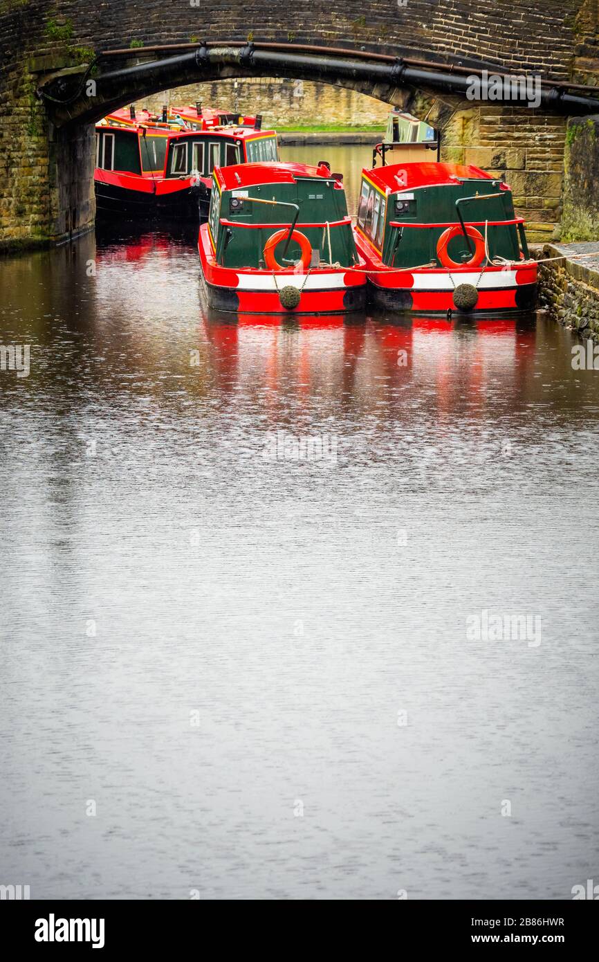 Red And White Painted Narrow Boats Under A Canal Bridge On The Leeds red-and-white-painted-narrow-boats-under-a-canal-bridge-on-the-leeds