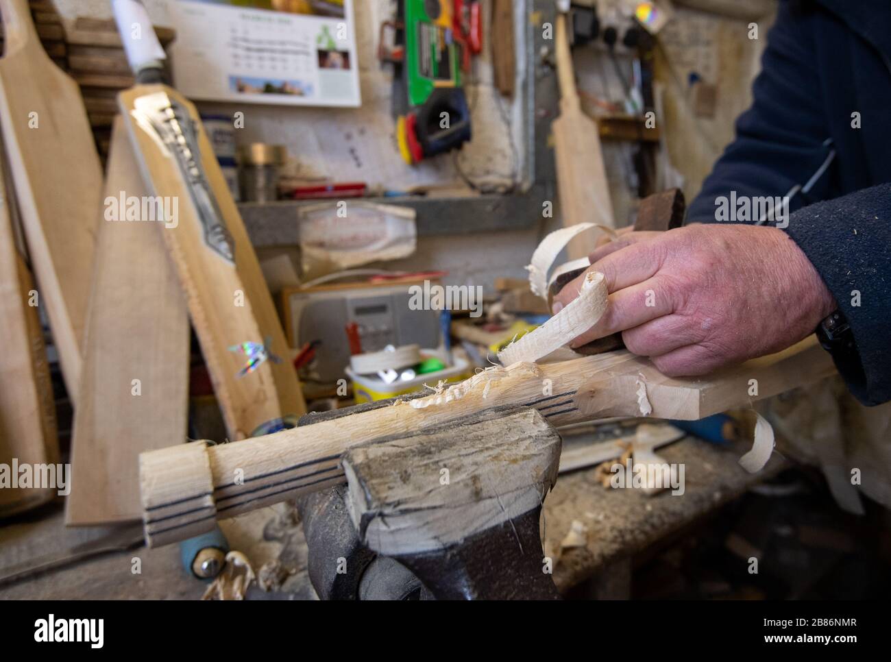 Batmaker Tony Sains crafts a handmade cricket bat at a workshop at Warsop Stebbing in East Hanningfield, Essex. With the start of the season just weeks away, the ECB, the governing body of cricket have recommend that all forms of recreational cricket are for now suspended. Stock Photo