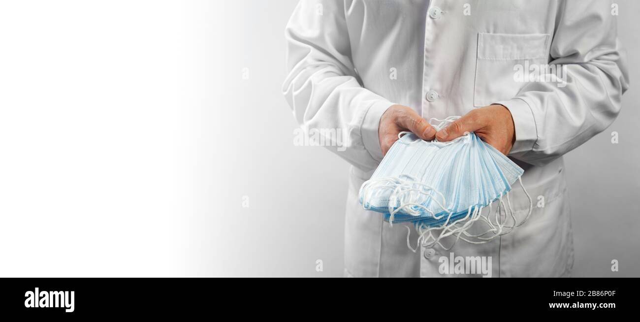 Medical masks. Doctor holds in hands a pile of medical protective bandage. Stock Photo
