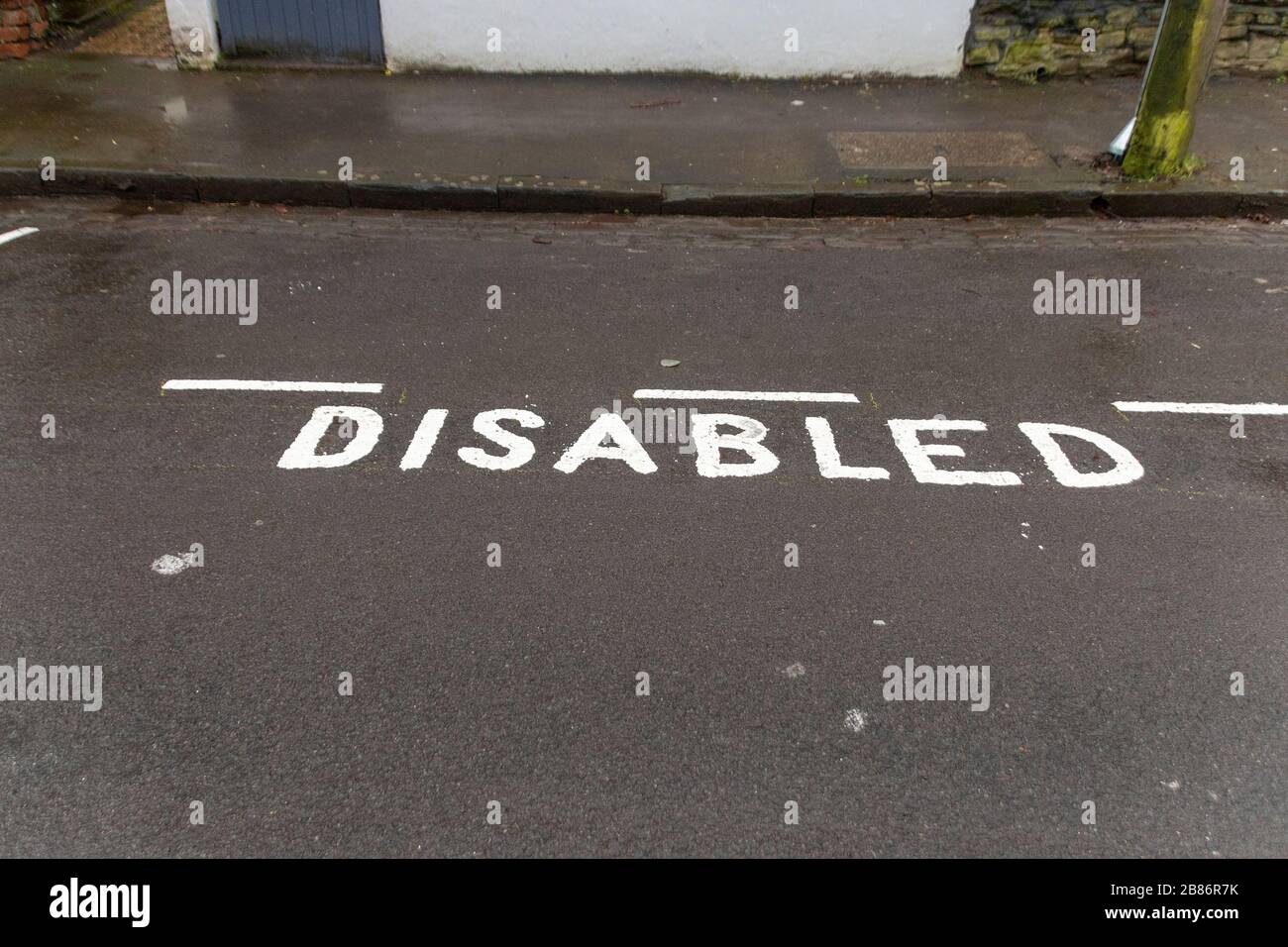 A close up view of a disabled parking area that has been marked off on the tar Stock Photo