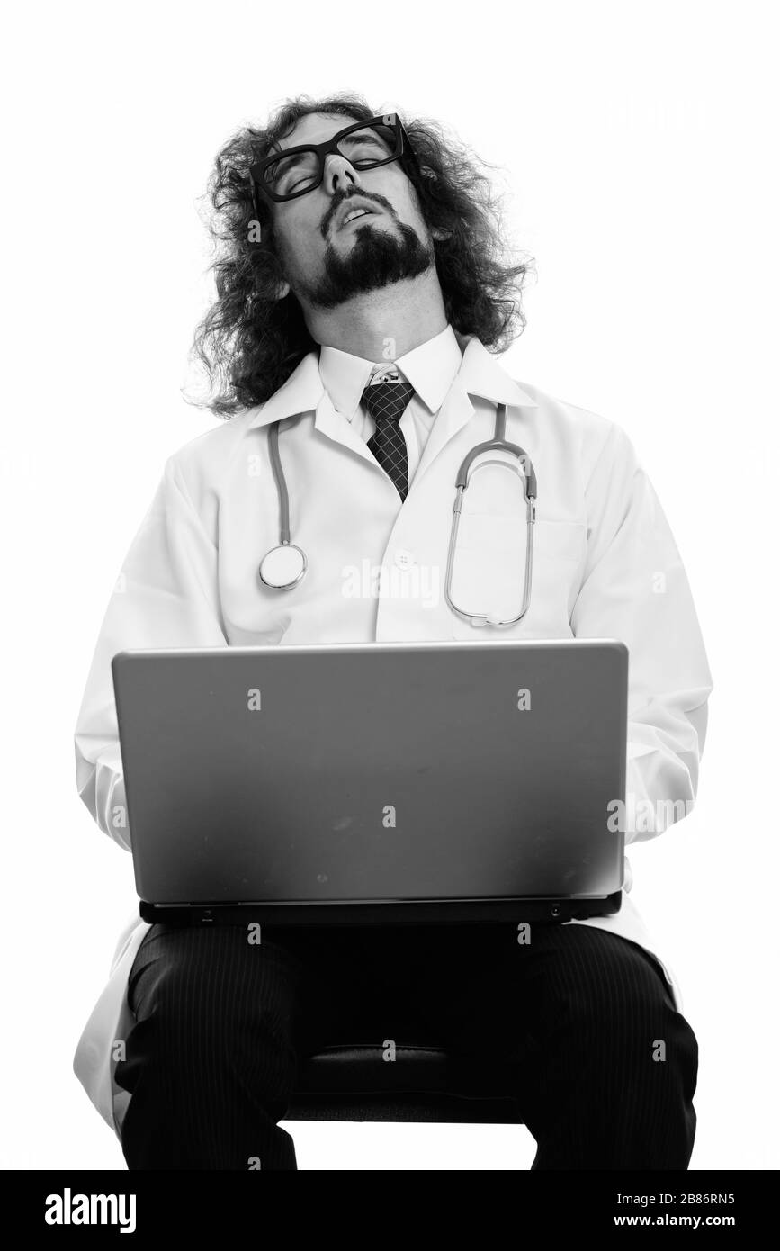 Studio shot of tired man doctor sleeping with laptop Stock Photo