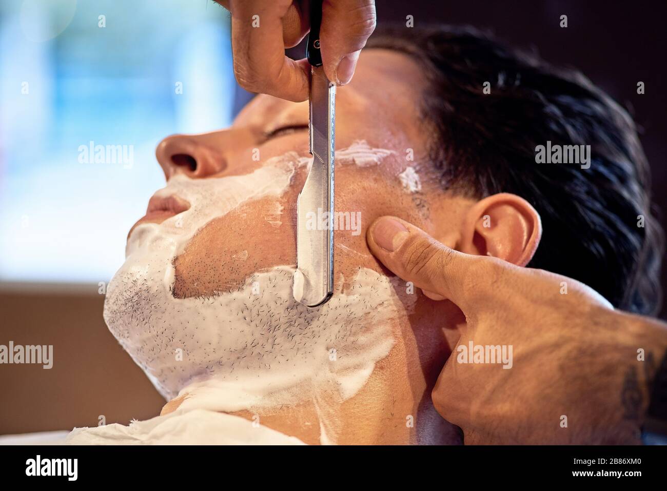 Shaving process of beards in Barbershop. Master makes the client shave his  beard with vintage straight razor. Work in the Barber shop, The process of  Stock Photo - Alamy