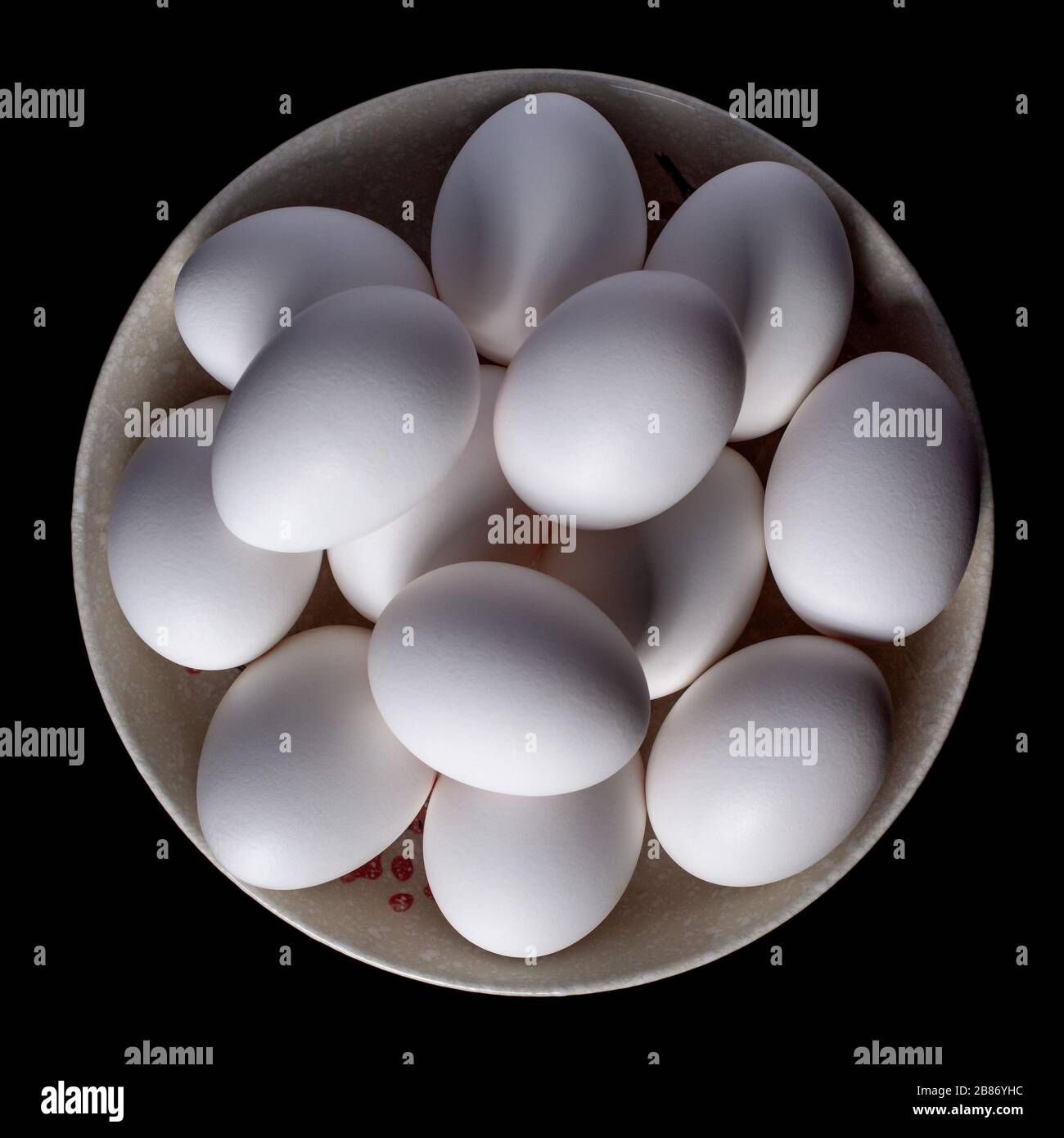 White organic chicken eggs placed in a plate on a black background ...