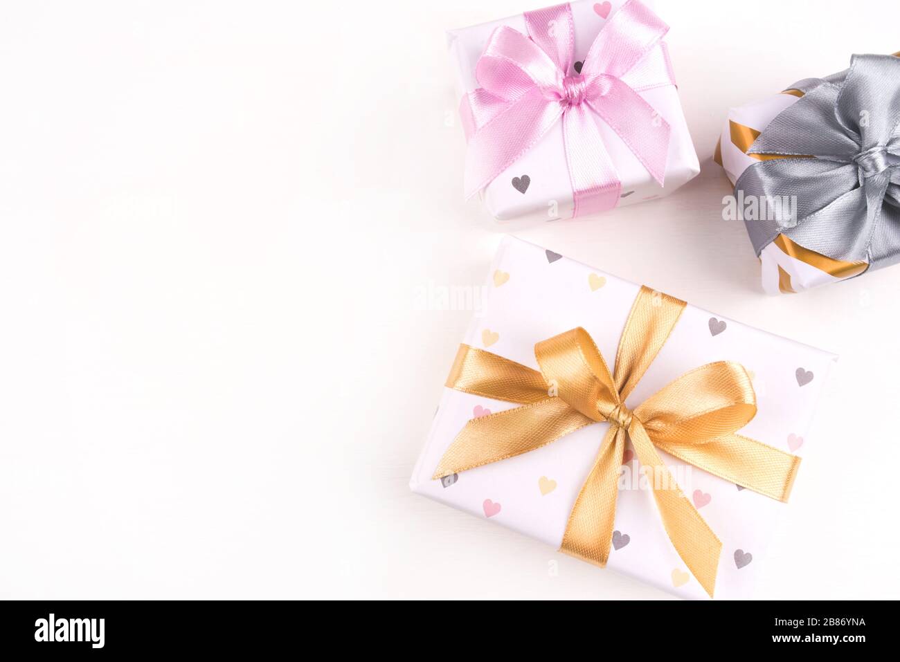 Three gift boxes with bows on a white background. Stock Photo