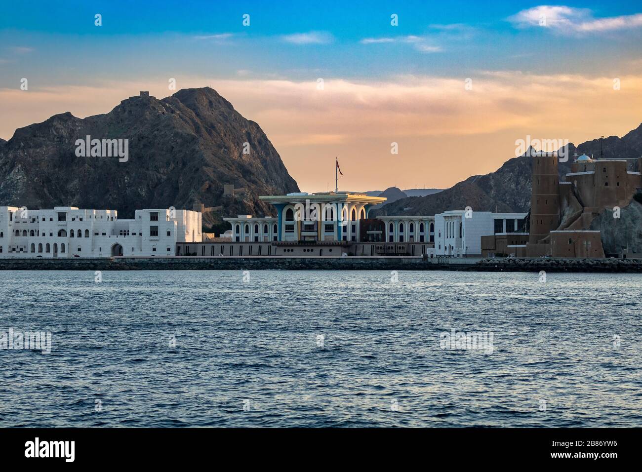 Muscat Al Alam palace from the coastal line with mountains in the background Stock Photo