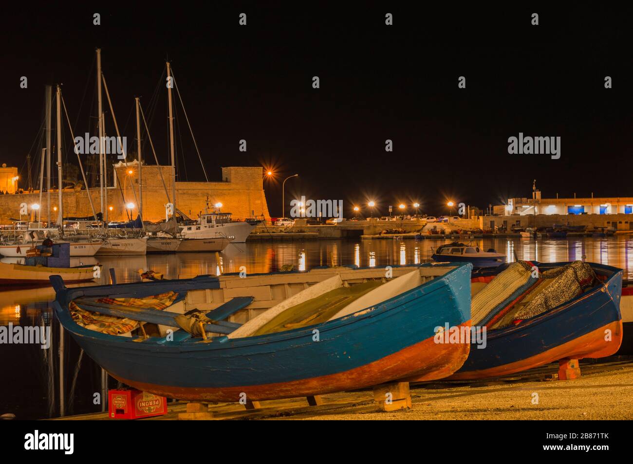 BARI, ITALY - FEBRUARY 16, 2020: rustic wooden boats and yachts in Bari fishing harbor at night Stock Photo
