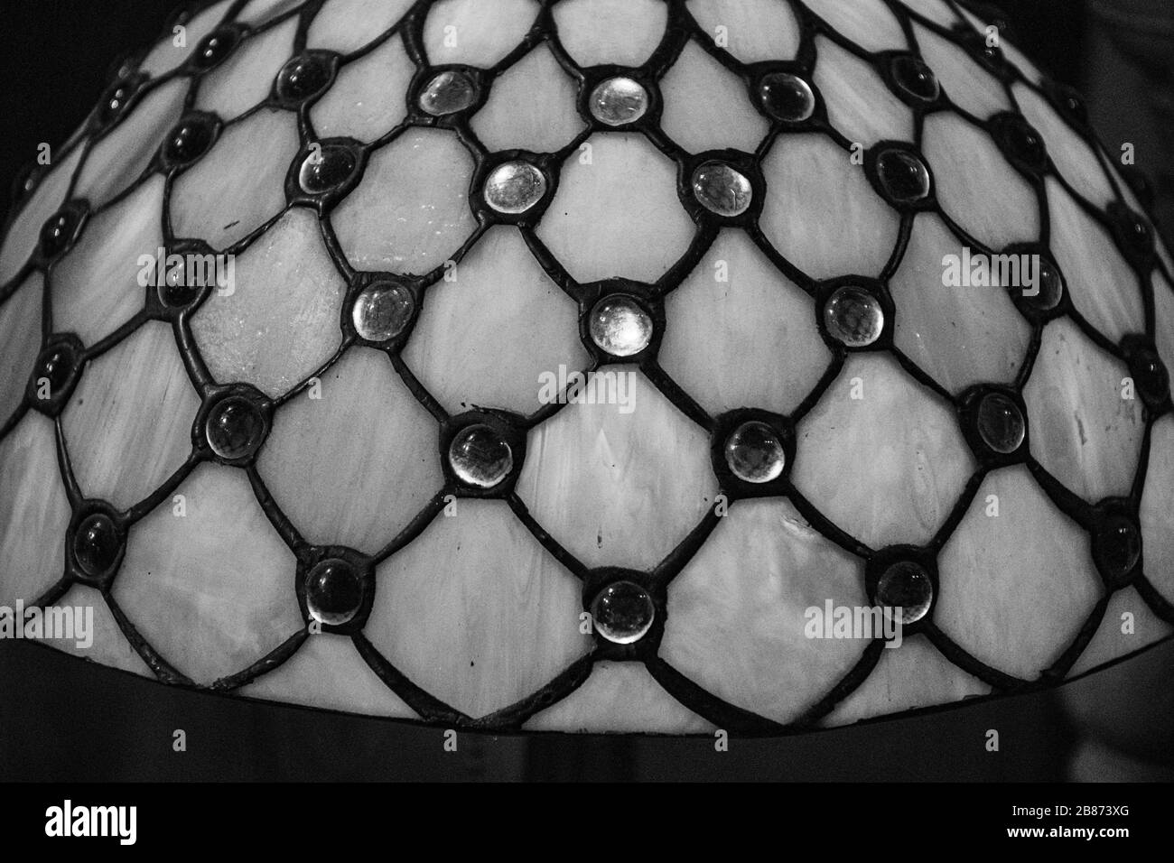 Black and white photo of stained glass surface with rhombus pattern and