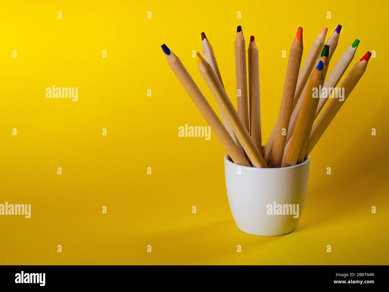 multi colored pencils on a yellow background 4 Stock Photo