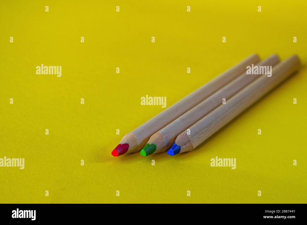 multi colored pencils on a yellow background Stock Photo