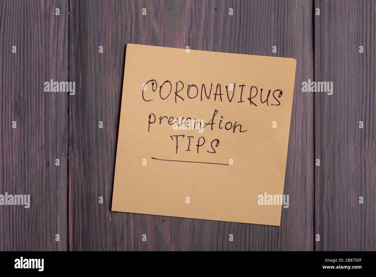 Text Coronavirus prevention tips on sticky note on wooden background - healthcare and medical concept Stock Photo