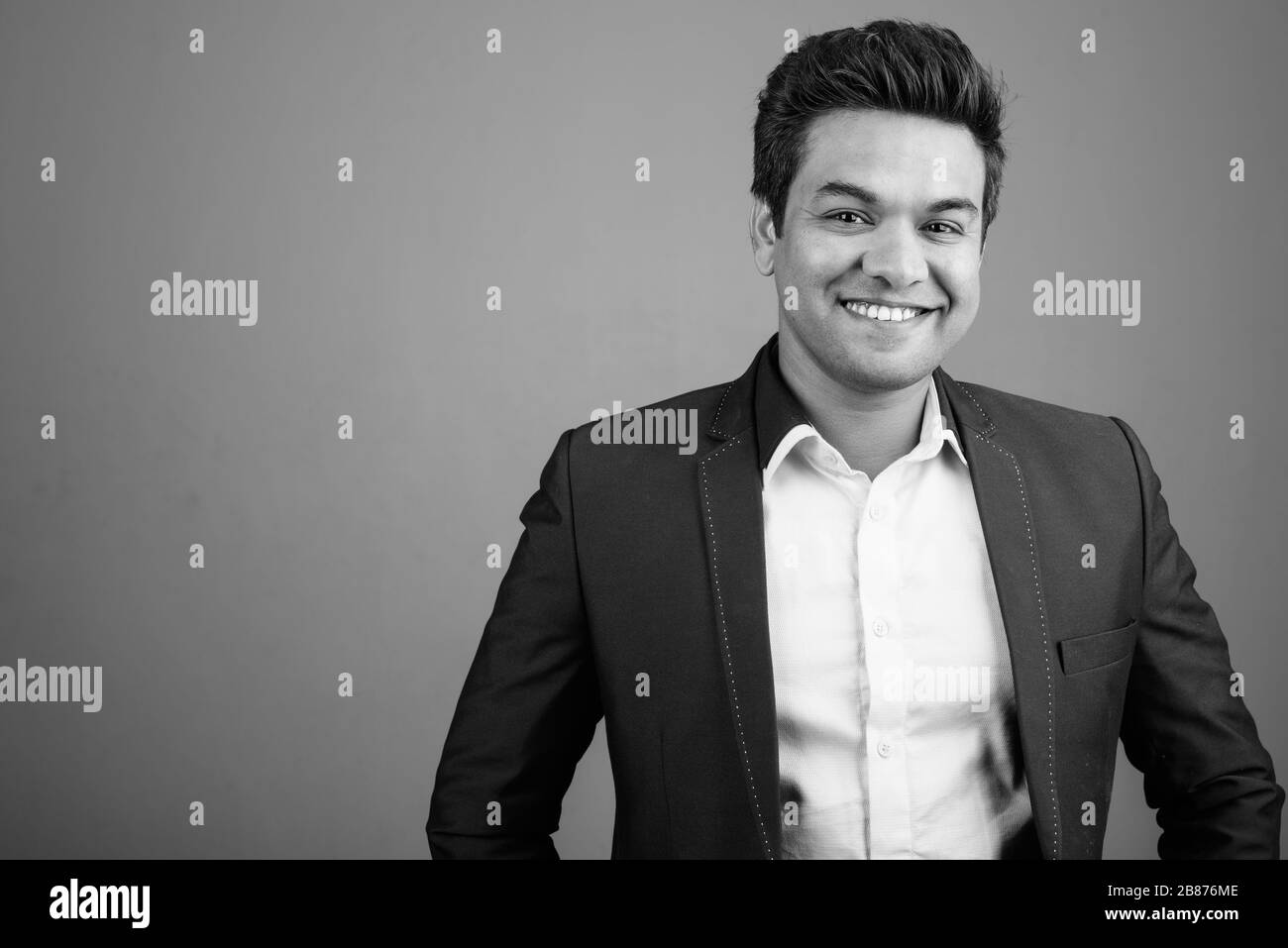Indian businessman wearing suit against gray background Stock Photo - Alamy