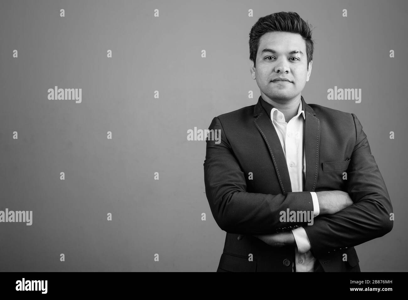 Indian businessman wearing suit against gray background Stock Photo - Alamy