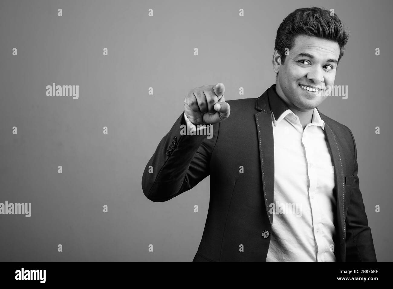 Indian businessman wearing suit against gray background Stock Photo - Alamy