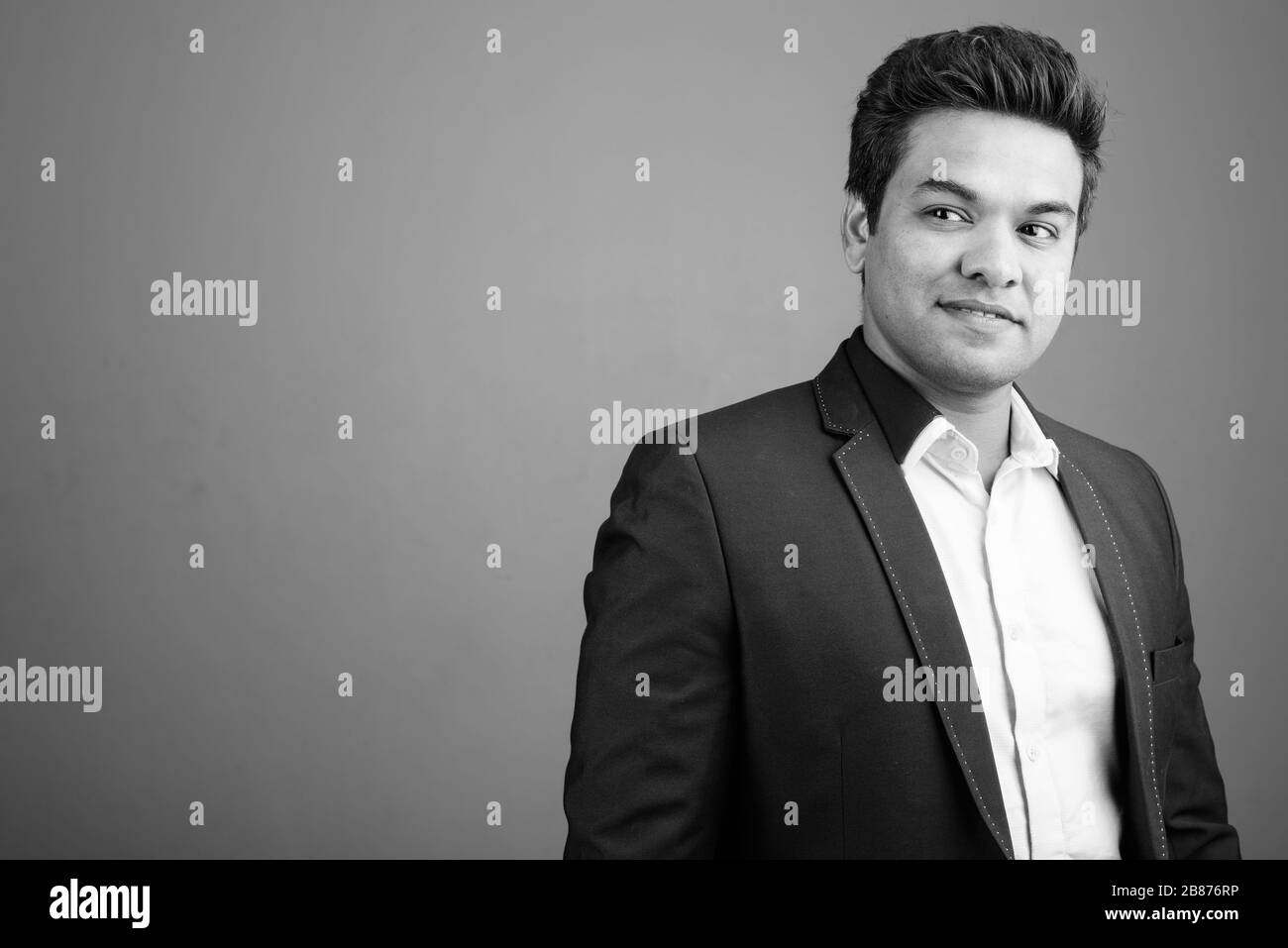 Indian businessman wearing suit against gray background Stock Photo - Alamy