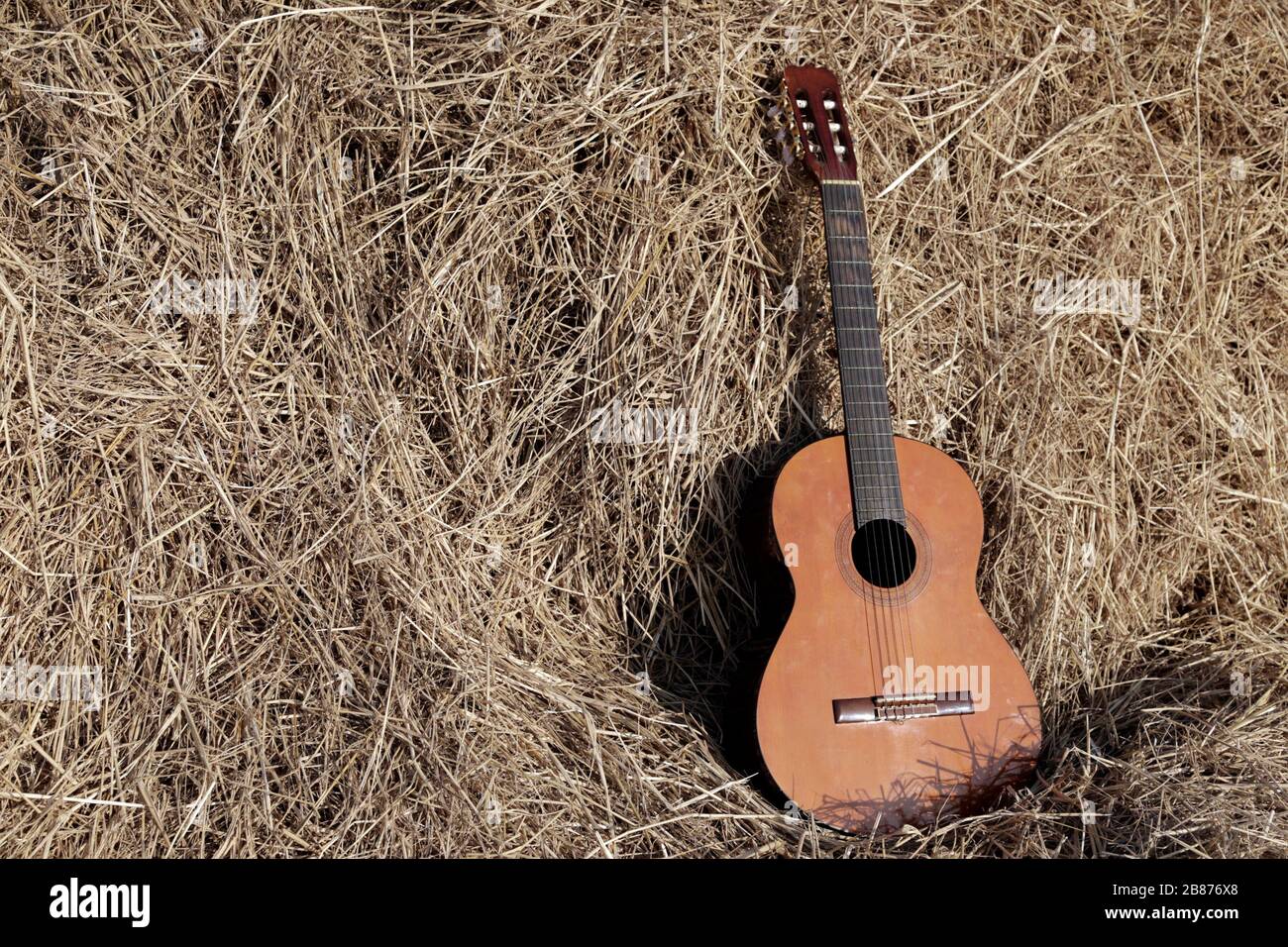 folk guitar on dry straw in country music concept Stock Photo