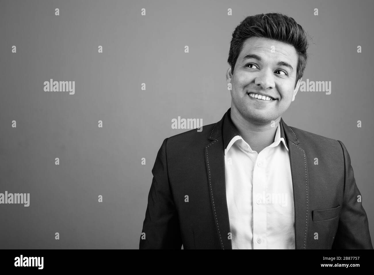 Indian businessman wearing suit against gray background Stock Photo - Alamy