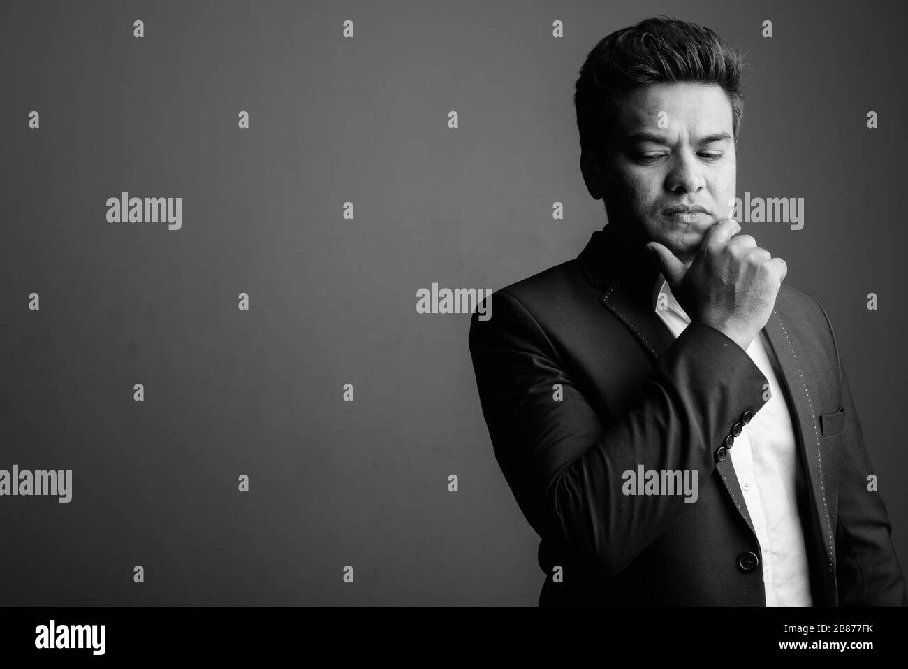 Indian businessman wearing suit against gray background Stock Photo - Alamy