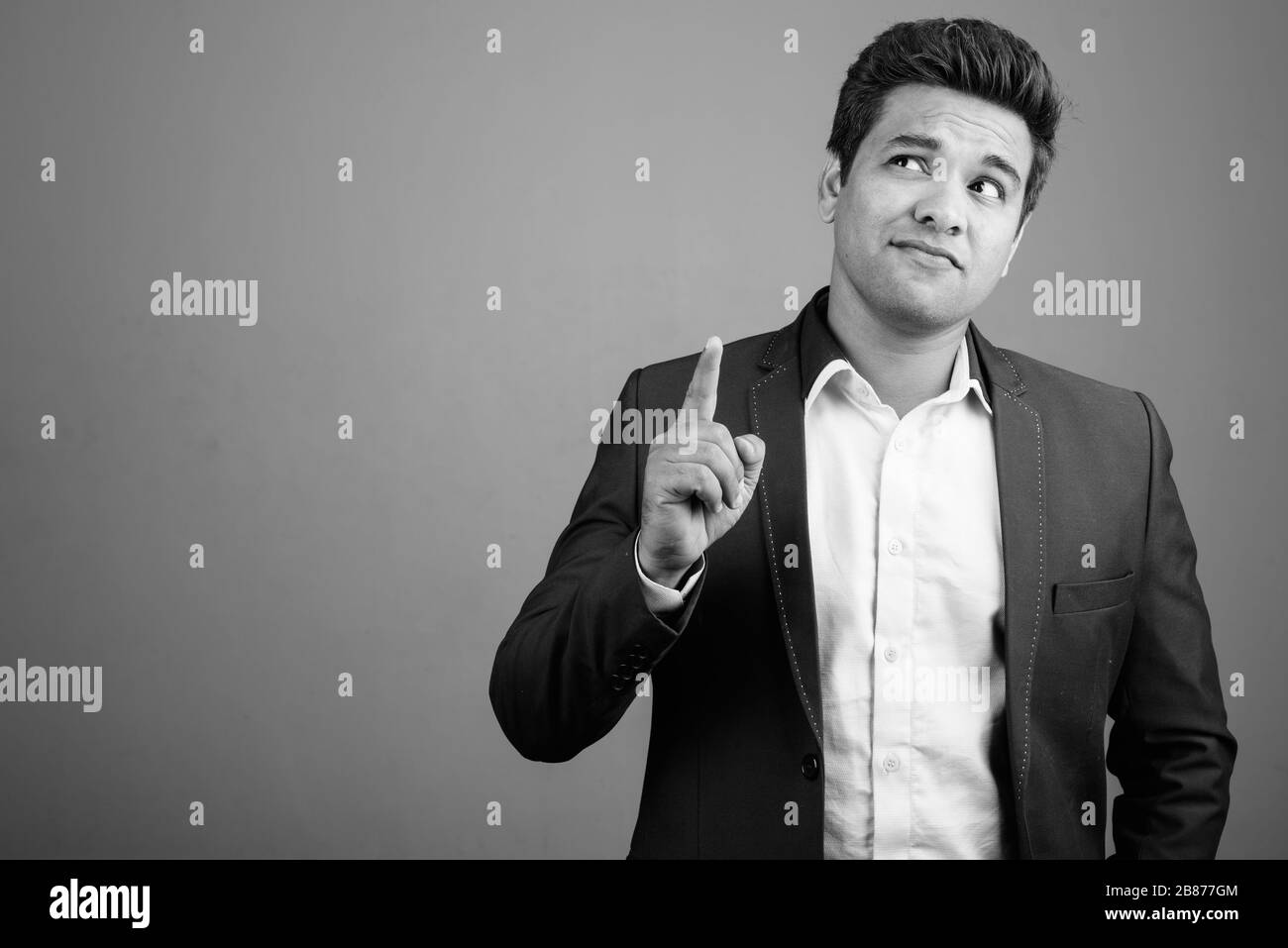 Indian businessman wearing suit against gray background Stock Photo - Alamy