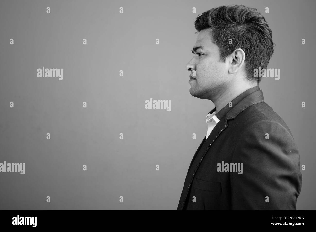 Indian businessman wearing suit against gray background Stock Photo - Alamy