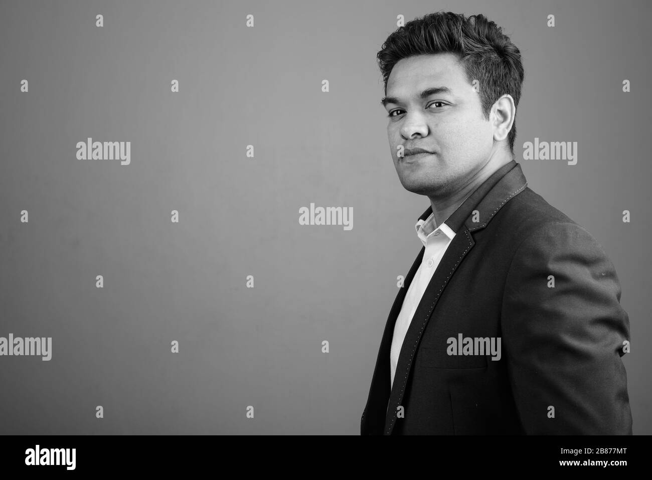 Indian businessman wearing suit against gray background Stock Photo - Alamy