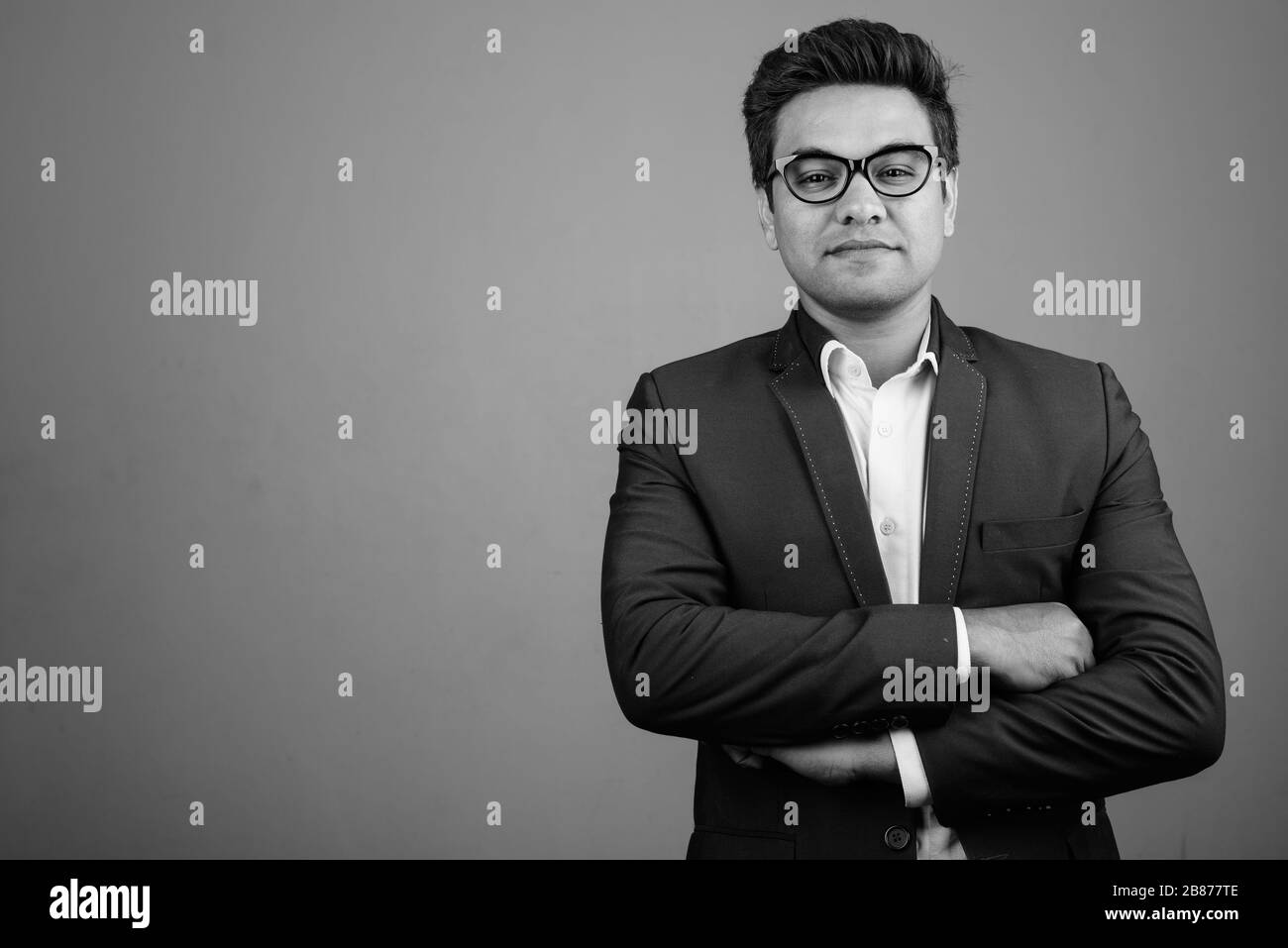 Indian businessman wearing suit against gray background Stock Photo - Alamy