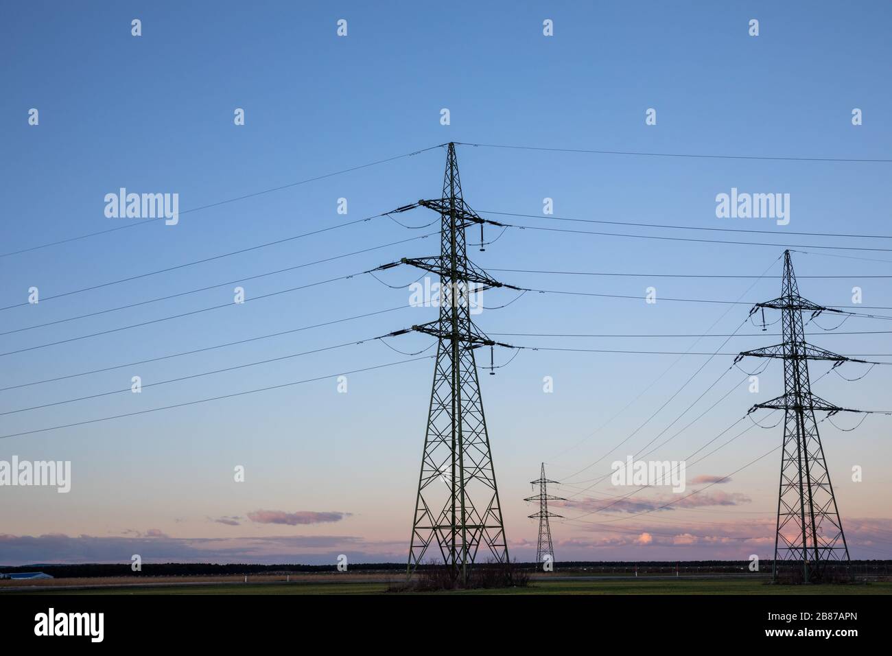 High voltage power lines with electricity pylons at twilight Stock ...