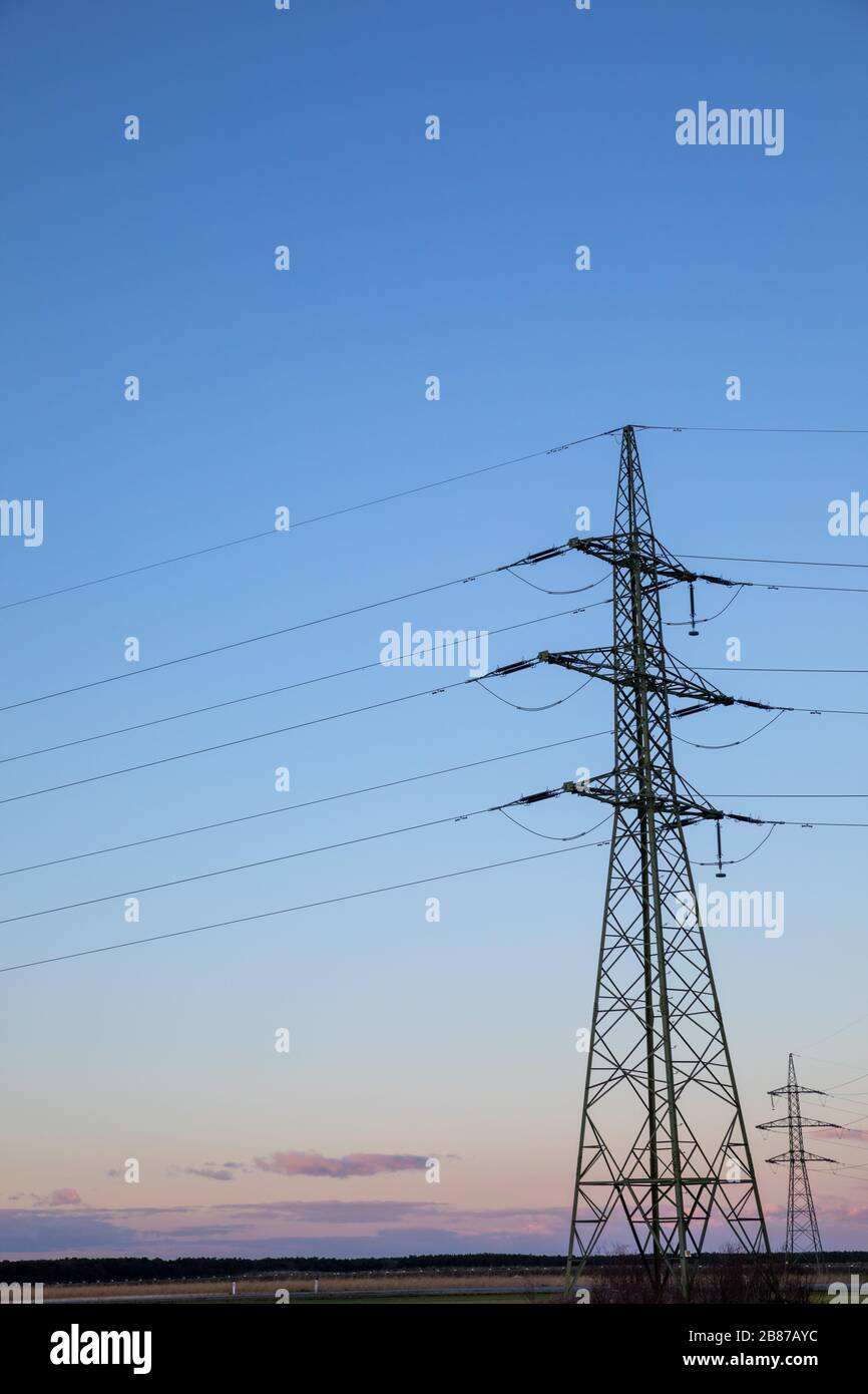 High voltage power lines with electricity pylons at twilight Stock ...