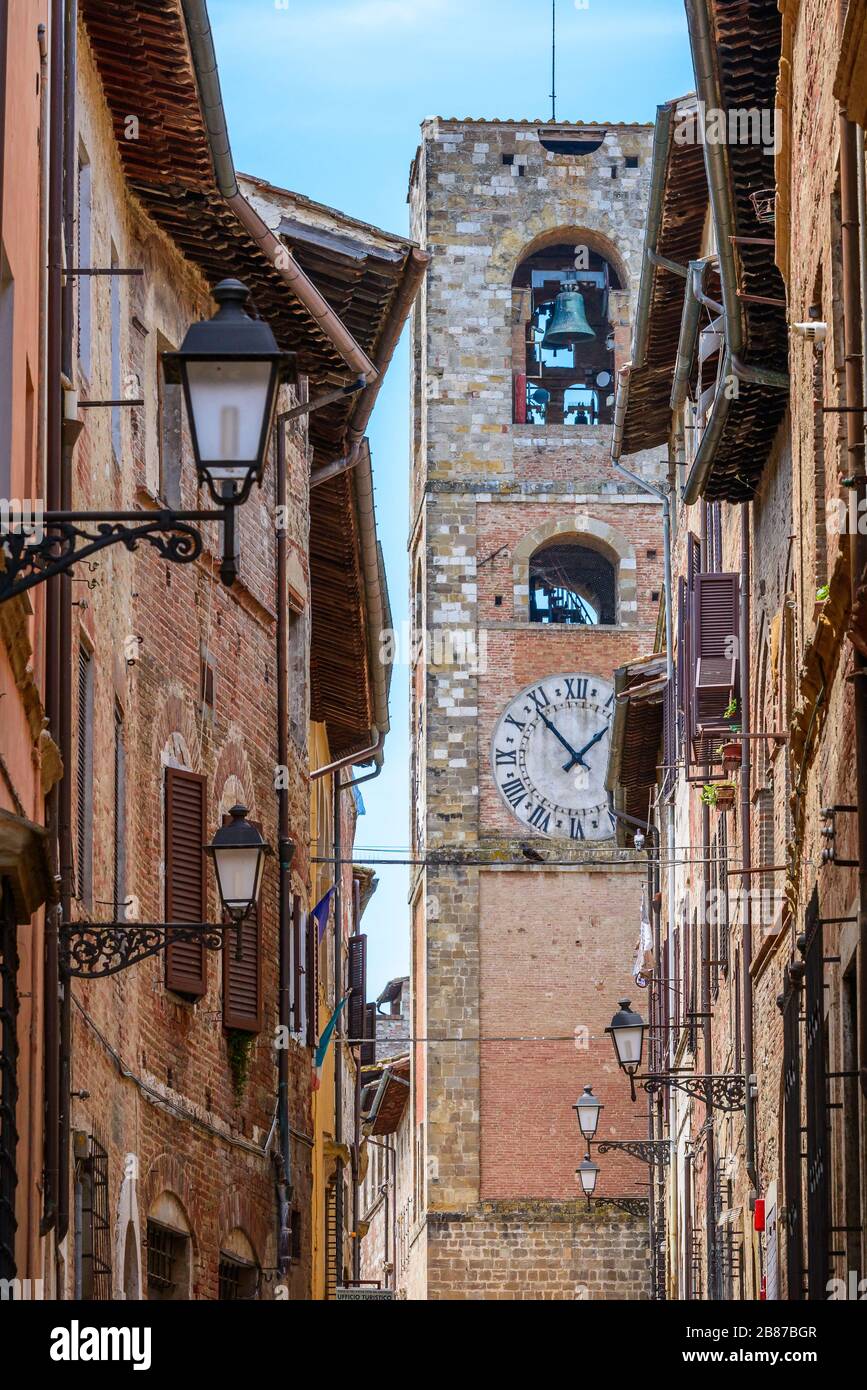 Colle di Val d'Elsa, Tuscany / Italy: A narrow street in the historic upper town Colle Alta with the Cathedral bell and clock tower in front. Stock Photo