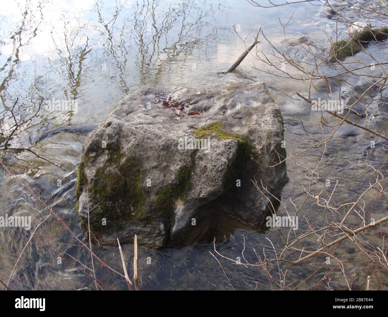 'Deutsch: kleiner Felsblock im Wasser (Bäume spiegeln sich leicht im Wasser); 2007; Self-photographed; Michael Hoelzl; ' Stock Photo