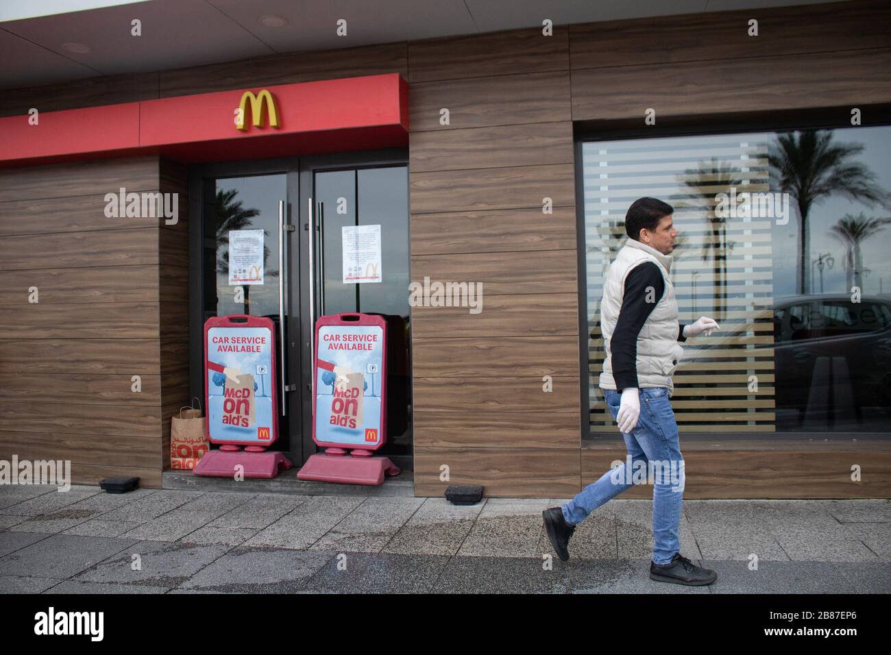 Beirut, Lebanon. 20 March 2020. A man walks past a closed McDonalds restaurant that is no longer serving diners due to the coronavirus outbreak. Credit: amer ghazzal/Alamy Live News Stock Photo