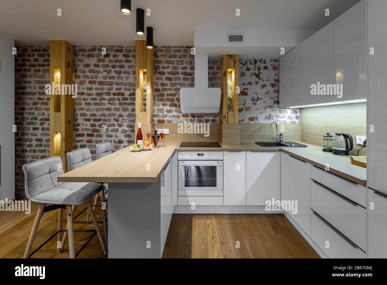 Modern contemporary loft interior of kitchen in studio apartment. Brick