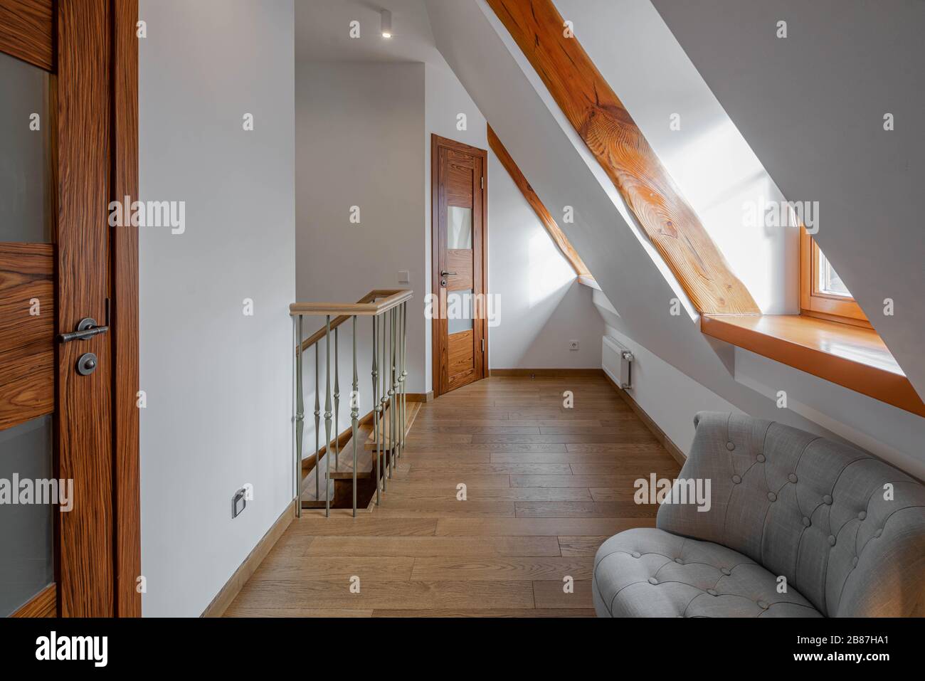 View of Modern loft interior of apartment. Chairs in hall. Staircase. Sloping ...