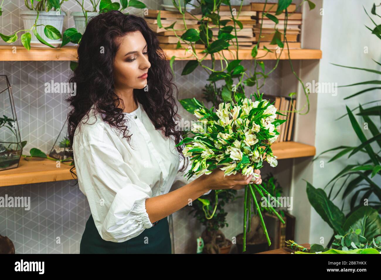 Attractive young woman florist is working in a flower shop. Stock Photo