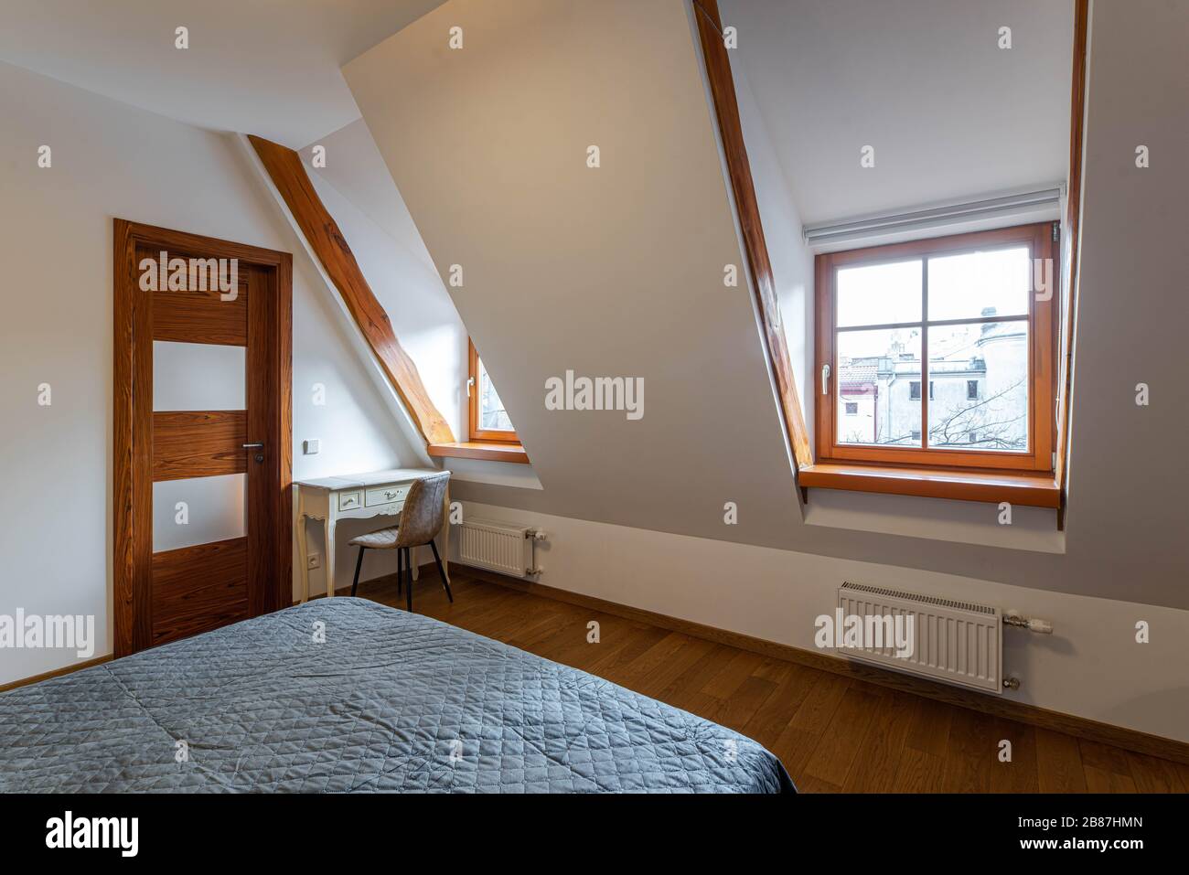 Modern loft interior of luxury bedroom. Cozy bed. Sloping ceiling with
