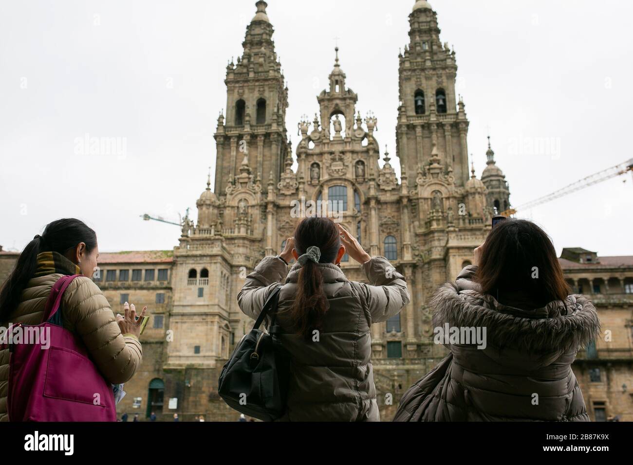 Chinese tourists taking pictures at he Santiago de Compostela's Cathedral. Obradoiro square . Galizia, Spain. Stock Photo