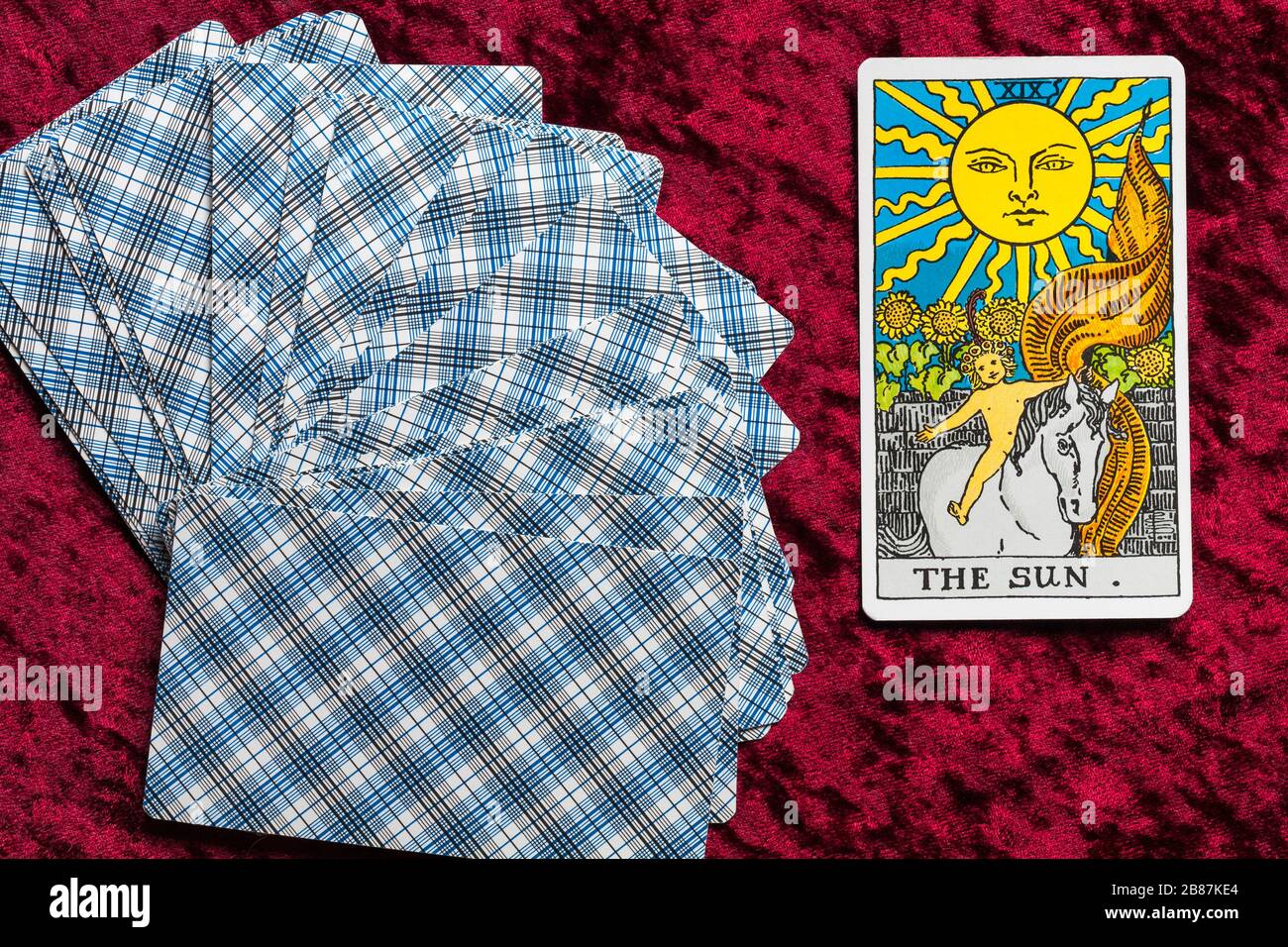Rider Tarot Cards designed by Pamela Colman Smith under supervision of Arthur Edward Waite fanned on red cloth with The Sun tarot card upturned Stock Photo
