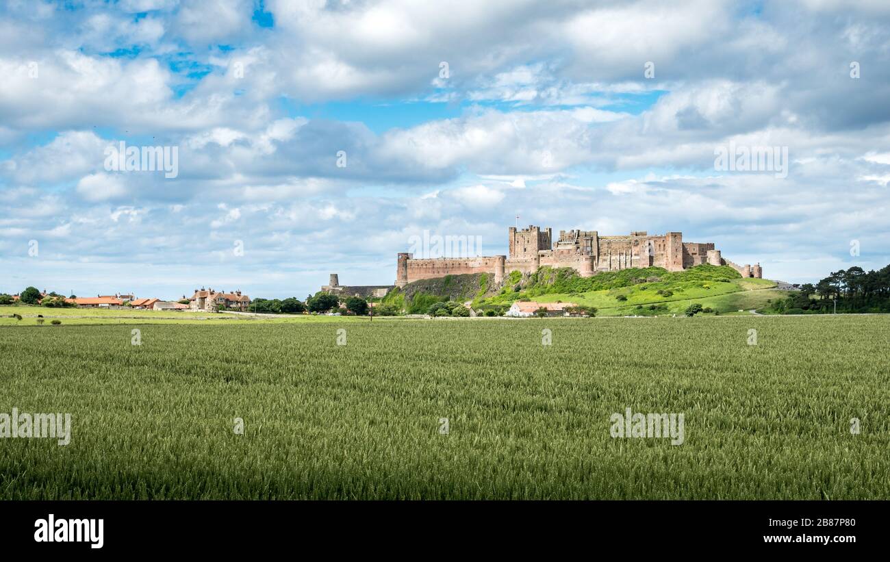 Bamburgh Castle, England. A view over the Northumberland countryside in the north east of England towards the landmark castle at Bamburgh. Stock Photo