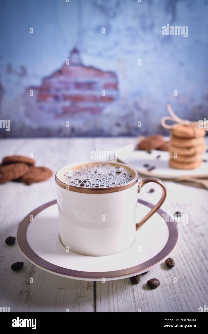 Roasted brown coffee beans and Hot coffee. Beautifully stacked cookies with chocolate on Wooden table. Chocolate chip cookies Vintage Color. Stock Photo